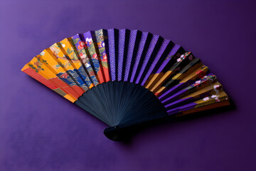 Elegant red and navy fan adorned with floral patterns displayed on a vibrant purple background showcasing traditional craftsmanship