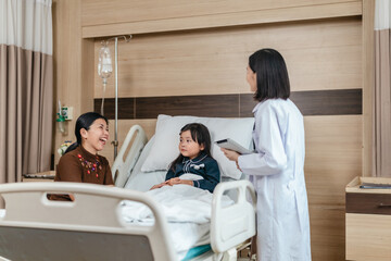 Caring Asian Female Doctor with Child Patient and Mother