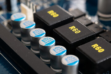 Capacitors or condensers in row on motherboard close up, electronic components