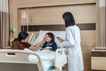 Obraz premium Caring Asian Female Doctor with Child Patient and Mother