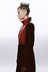 woman with colorful rainbow shaved hair wearing a red leather coat and black crown standing in...