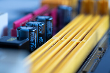 Capacitors or condensers in row on motherboard next to ram ports close up, electronic components