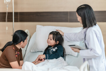 Caring Asian Female Doctor with Child Patient and Mother