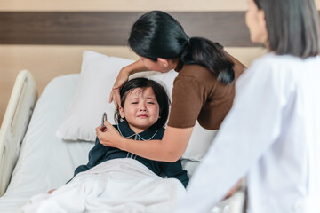 Caring Asian Female Doctor with Child Patient and Mother