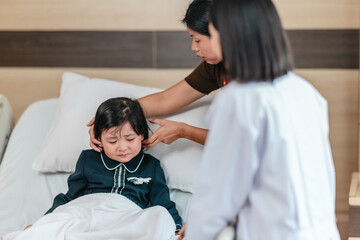 Caring Asian Female Doctor with Child Patient and Mother