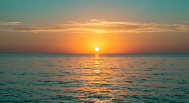 Bright sun setting over calm ocean water with orange and teal sky sunset