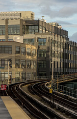 train arriving on platform in court square queens long island city new york nyc famous outdoor elevated station stop seven 7 metro commuter line tall buildings in background tracks railroad track