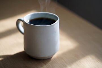 Steaming hot coffee in white mug on wooden table morning coffee break caffeine boost energy drink