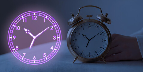 Classic alarm clock held by hand next to glowing neon clock graphic, both showing the same time at night. Copy space.