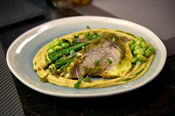 Deliciously Prepared Fish Fillet with Creamy Sauce, Complemented by Fresh Asparagus and Edamame, Showcasing an Elegant Culinary Presentation