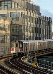 train arriving on platform in court square queens long island city new york nyc famous outdoor elevated station stop seven 7 metro commuter line tall buildings in background tracks railroad track