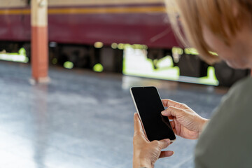 Happy Asian senior boarding a train at the station