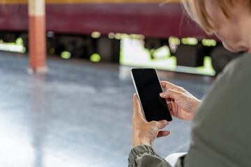 Happy Asian senior boarding a train at the station