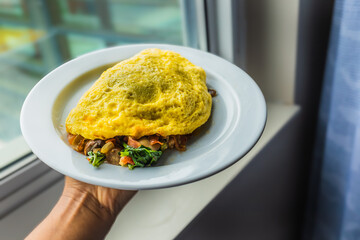 Omelete, desayuno tradicional americano servido con una mano.