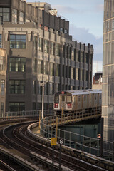 train arriving on platform in court square queens long island city new york nyc famous outdoor elevated station stop seven 7 metro commuter line tall buildings in background tracks railroad track