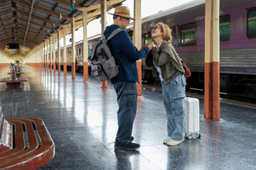 Happy Asian senior boarding a train at the station