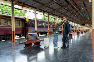 Fototapeta premium Happy Asian senior boarding a train at the station
