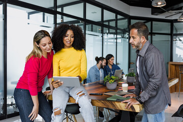 latin business people having a discussion and working in an office in Mexico Latin America, hispanic coworkers using laptop or tablet