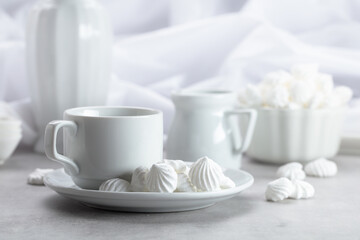 Vanilla meringue and coffee cup on a white marble table.