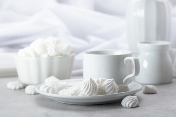 Vanilla meringue and coffee cup on a white marble table.