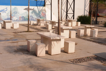 Outdoor cafe or coffee shop with a table and chairs set made of white natural stone. Modern interior design concept and furniture.
