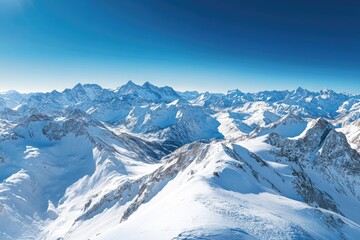 Panoramic alpine vista. Snow-capped peaks and ridges under a vibrant blue sky