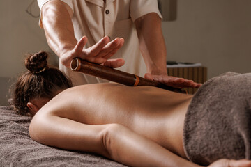 Bamboo Massage Therapy on Back in Spa for Relaxation and Wellness