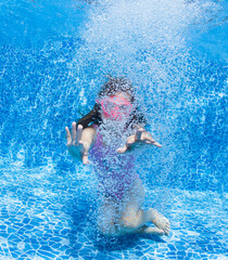 A little girl is surrounded by a million bubbles after jumping into a pool.