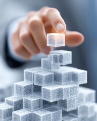 A close-up of a hand placing a translucent cube onto a growing structure of cubes, symbolizing innovation, strategy, and success in business development.