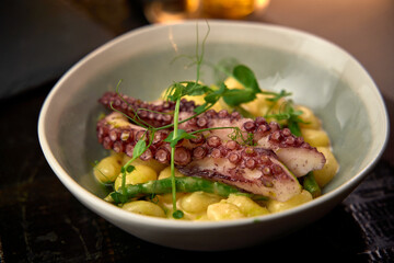 A Gourmet Octopus Dish Served on Gnocchi with Fresh Peas and Asparagus in a Stylish Bowl Enhancing Culinary Aesthetics and Flavor