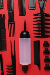 Different hairdresser's tools on red background, flat lay