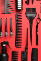 Different hairdresser's tools on red background, flat lay