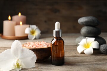 Composition with cosmetic product and spa stones on wooden table, closeup
