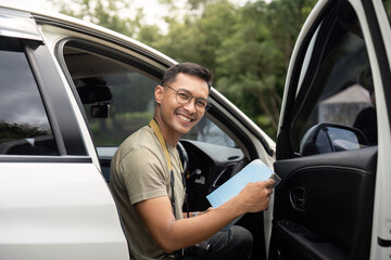 Young man smiling while sitting in a car
