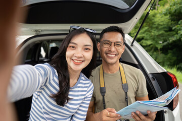 Couple enjoying road trip adventure, taking selfies and exploring