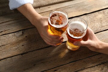 Friends with glasses of beer at wooden table, above view