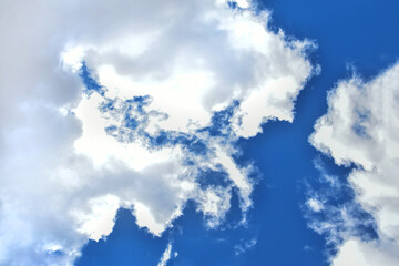 Fluffy white clouds on bright blue sky