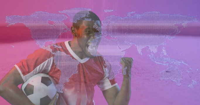 Shouting soccer player in red and white jersey gripping ball before pink backdrop with map overlay