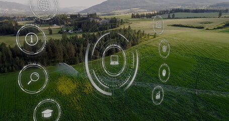 Displaying interface with laptop icon hovering over farmland, with irrigation sprinklers