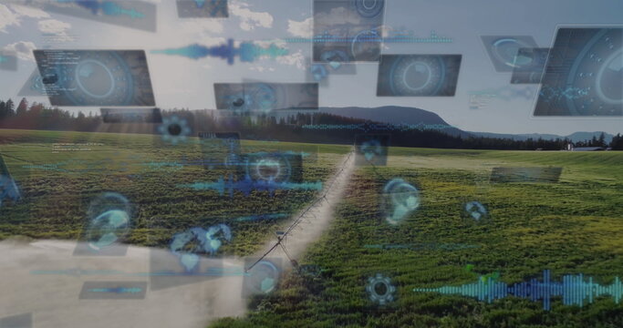 Monitoring aerial irrigation pipeline sprinkling water over green farmland, with digital HUD panels
