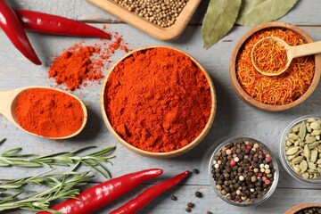 Different aromatic spices on grey wooden table, flat lay