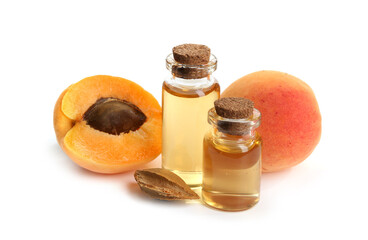 Bottles of essential oil, fresh apricots and kernel isolated on white