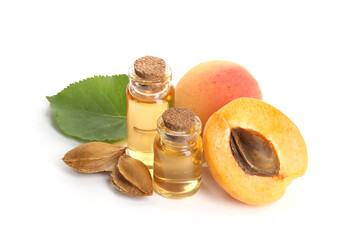 Bottles of essential oil, fresh apricots, kernels and green leaf isolated on white
