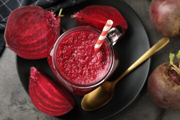 Superfood. Refreshing smoothie in mason jar and beetroots on grey textured table, flat lay