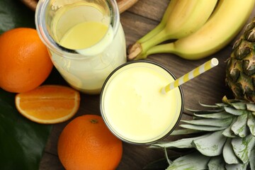 Superfood. Refreshing smoothie in bottle, glass and ingredients on wooden table, flat lay