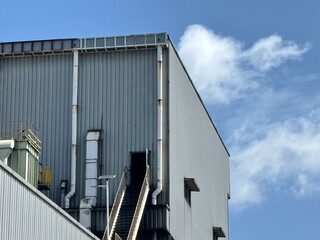 The robust exterior of an industrial building, featuring corrugated metal siding, utilitarian...