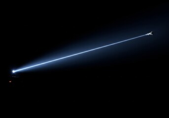 Laser Beam Across Night Sky - A powerful laser beam cuts across a dark night sky, a bright streak of light against the black background