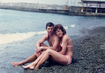 Vintage portrait of middle aged man and woman on the beach during their honeymoon. Retro 1985.