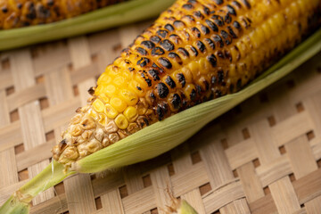 Grilled corn cobs on vintage wood background with lemon, salt, and green chutney or thecha butter
