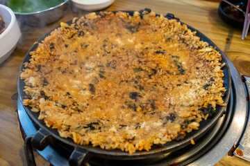 Crispy fried rice on pan, made by mixing rice, seaweed and sauce. Korean food